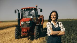 Agricultrice devant son tracteur dans le cadre d'une transmission d'exploitation agricole avec pacte Dutreil